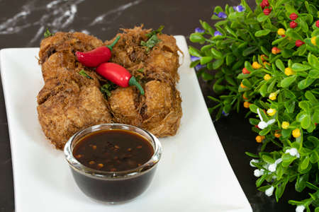 A serving of tauhu bergedil, a famous Malaysian dish with spicy soy sauce as dips. Blurred...
