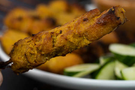 Satay is skewered meat on a bamboo stick then grilled on charcoal fire eaten with peanut gravy. Satay is a famous street food in South East Asia. Selective focus