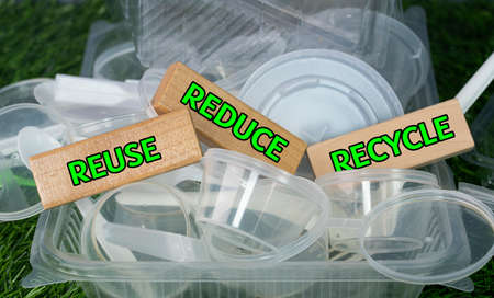 Environmental concept. Plastic containers and spoons with wooden block. Selective focus points....