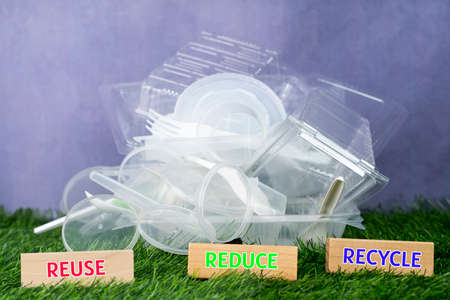 Environmental concept. Plastic containers and spoons with wooden block. Selective focus points....