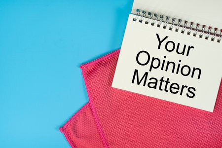 Business concept. Layout of red napkin and spiral notebook with text. Customer service evaluation.の写真素材