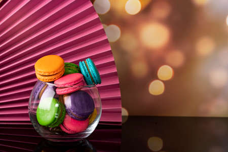 Delicious macaroons, a famous multicoloured French dessert in a clear crystal glass. Selective focus. Blurred backgroundの写真素材