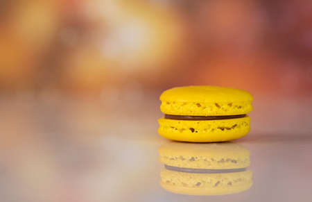 Single yellow delicious macaroons, a famous multicoloured French dessert. Blurred backgroundの写真素材