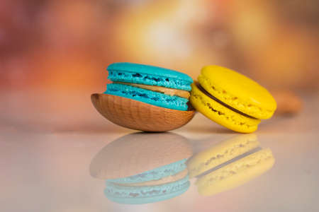 Delicious macaroons, a famous multicoloured French dessert with a wooden spoon. Selective focus. Blurred backgroundの写真素材