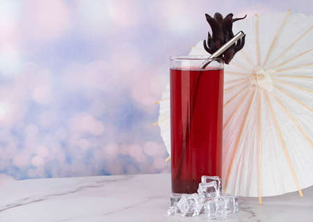 A glass of Roselle drinks with metal straw and paper umbrellaの写真素材