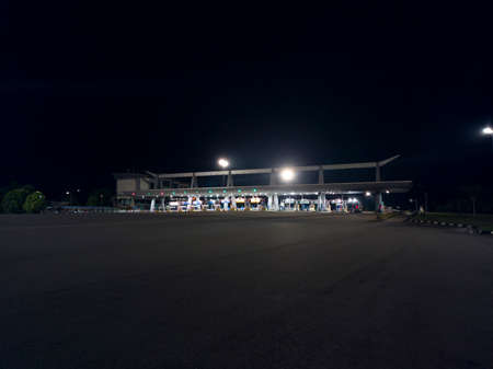 A wide view of the toll plaza at night with floodlights. Selective focus points
