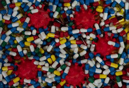 Studies to introduce anti-covid pills to fight the virus. Model of virus surrounded by various pills. Health concept. Selective focus pointsの写真素材