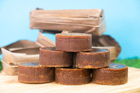 A stack of the palm sugar with dried coconut leaves used for packing. Selective focus points. Blurred backgroundの写真素材