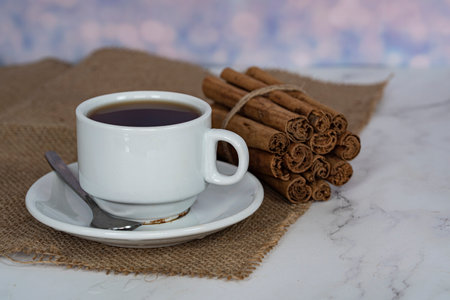 A cup of tea with a stack of cinnamon sticks on the side. Selective focus points. Blurred backgroundの写真素材