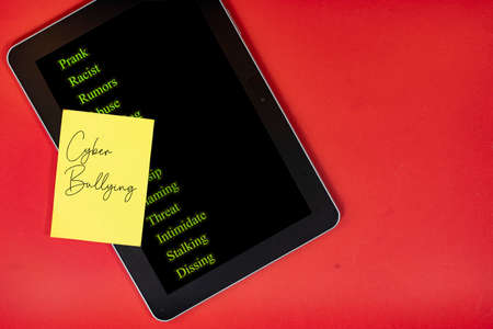 Layout of a tablet and a note texts of cyberbullying actions. Cyberbullying conceptの写真素材