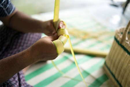 Weaving the coconut leaves making the ketupat, a traditional Malay cuisine during the Eid celebration. Selective focus pointsの写真素材