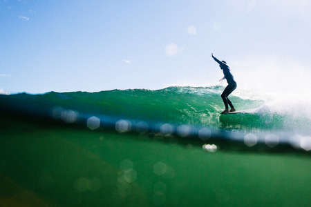 Overunder shot of longboard surfer hanging tenの写真素材