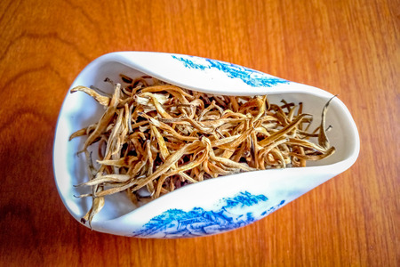 Puer tea in a container on wooden backgroundの写真素材