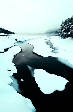 Snow Creek Flowing into Winter Lakeの写真素材
