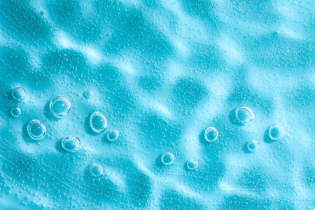 Water ripple with sun spot in Blue abstract water with bubbles. Macro. Closeup. Copy-space.