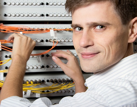 The engineer in a data processing center of ISP Internet Service Provider hold fiber patch cords