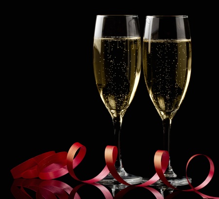 Two glasses with white wine over black background with red ribbon Two glasses with white wine over black background with red ribbon