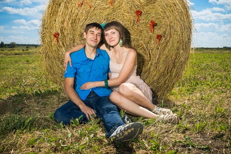 Young couple sitting near haystackの写真素材