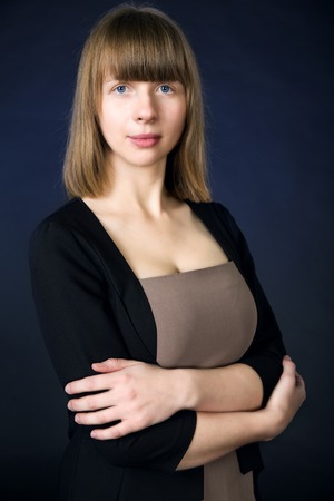 Woman in casual business suit over dark blue background.の写真素材