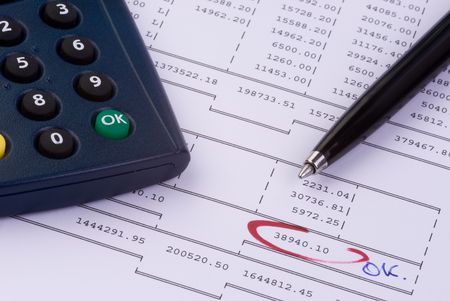a pen and a calculator on a balance sheet a pen and a calculator on a balance sheet