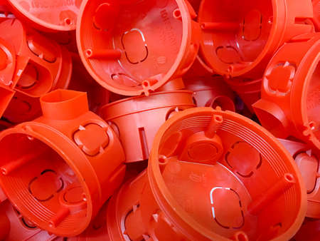 A lot red plastic enclosures for installation of electrical outlet. Wiring in the building