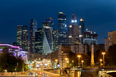 Moscow high-rise buildings against the background of the deep blue evening sky. Old residential high-rise buildings and modern skyscrapers of the Moscow-City business center. Russia - May 25, 2021.のeditorial素材