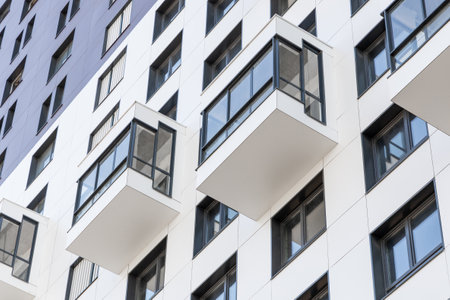 Small balconies on the facade of a modern residential multi-storey building. Viewed from below, close-up. Condominium in a laconic design. Modern apartments. Moscow, Russia - August 15, 2020のeditorial素材
