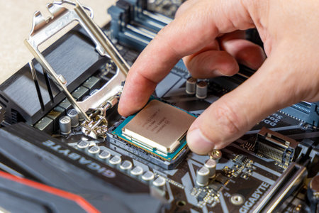 Installing the Intel i7-9700K central processor on the Gigabyte motherboard. The CPU is installed in the motherboard connector. DIY PC assembly or upgrade concept. Moscow, Russia - May 16, 2020のeditorial素材