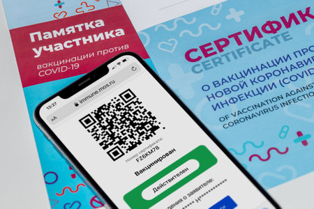 iPhone with a Russian QR-code confirming vaccination against COVID-19 and a certificate of vaccination against coronavirus. Vaccinated and Valid statuses. Moscow, Russia - November 22, 2021のeditorial素材