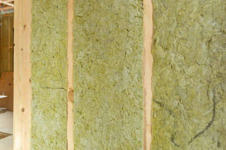 Rock wool insulation between wooden studs. Insulation of walls in a wooden frame house with rock...
