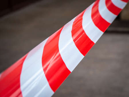 Stretched white-red warning tape. Close-upの写真素材