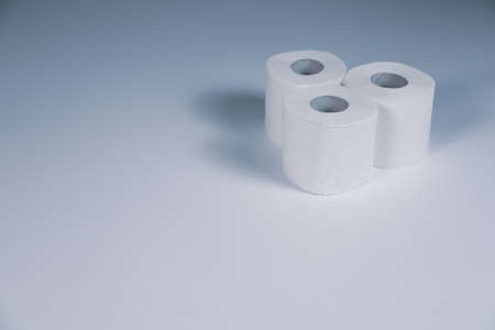 Three rolls of white toilet paper. Toned image. Cleanliness and hygiene in the home. Copy space