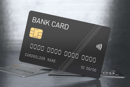 Black plastic bank cards on a shiny metallic background. Banking and e-commerce concept. Credit card without branding, selected focusの写真素材