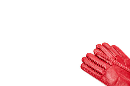 A pair of red leather womens gloves is in the lower right corner of the image. Isolate on white background, top view, copy space. Template for design about fashion and accessoriesの写真素材