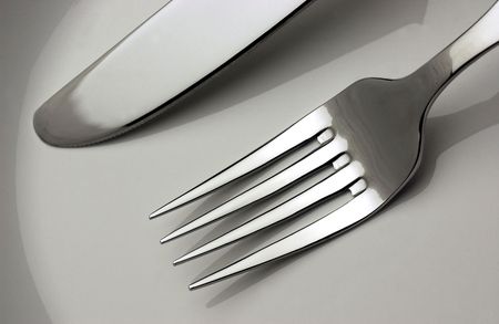 fork and knife in a plateの写真素材