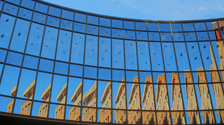 mirrored semicircular window front reflecting parts of a building and the blue sky aroundのeditorial素材