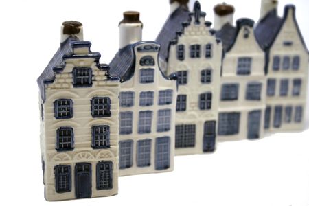 blue and white (delfts blue aka dutch china) ceramic houses in a row isolated on whiteの写真素材