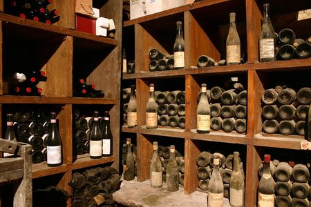ancient wine bottles gathering dust in italian wine cellar