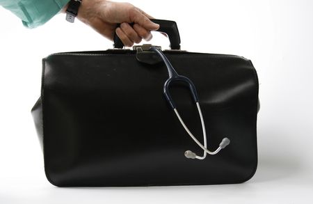 hand holds big black leather doctor's bag with stethoscope hanging outの写真素材