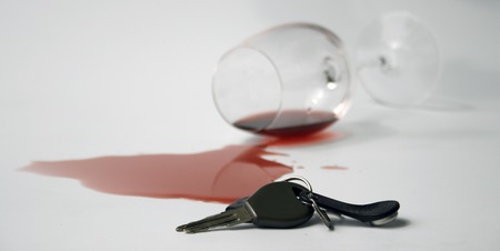 carkeys with fallen glass with red wine spilled in backgroundの写真素材