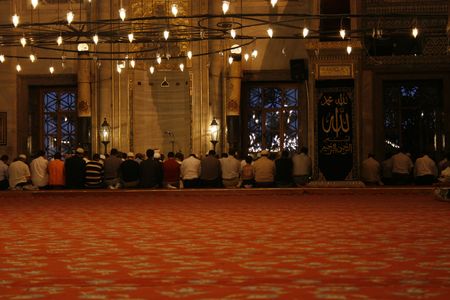 Men sitting on knees and praying during Ramadan in Blue Mosque, Istanbul in Turkeyのeditorial素材