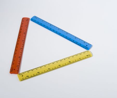 a colorful triangle of red, yellow and blue rulers on white backgroundの写真素材