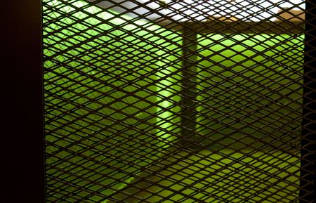 grated interor fence with green lightの写真素材