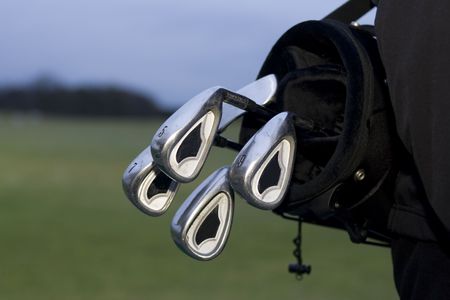black golfbag with clubs hanging out on back of golferの写真素材