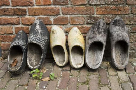 A row of Dutch wooden shoes standing against a brick の写真素材