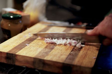 cutting onions on a wooden boardの写真素材