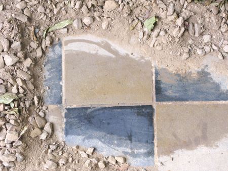Old hidden tiles under modern gravel の写真素材