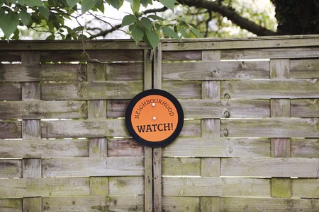 Orange neighbourhood sign attached to a garden fence in the cotswoldsの写真素材