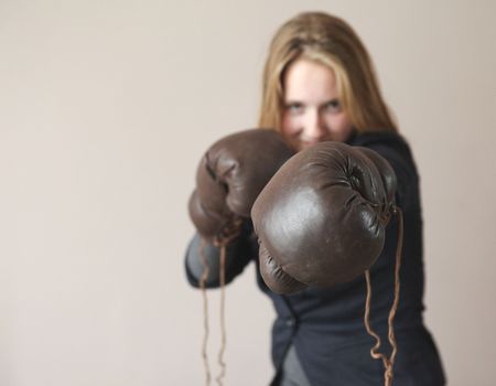 Pretty young woman with boxing gloves giving a punchの写真素材