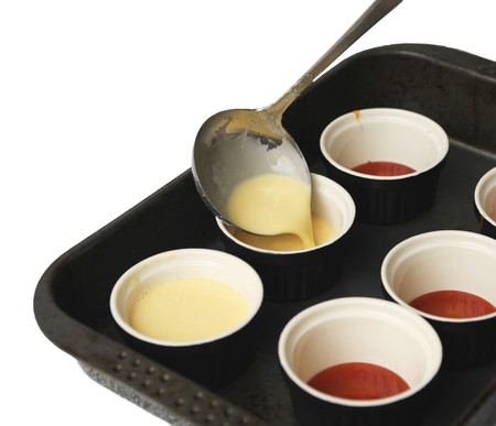 Pouring the creme into pots for creme caramel.の写真素材